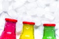 Colorful plastic bottles with ice cubes white desk background to Royalty Free Stock Photo