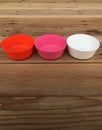 Colorful plastic bowls on wood background. Royalty Free Stock Photo