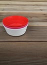 Colorful plastic bowls on wood background. Royalty Free Stock Photo