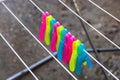 Colorful plastic clothes pegs on empty metal clothes dryer