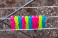 Colorful plastic clothes pegs on empty metal clothes dryer