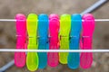 Colorful plastic clothes pegs on empty metal clothes dryer Royalty Free Stock Photo