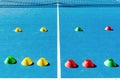 Colorful plastic cones on a blue cement tennis court with white lines background Royalty Free Stock Photo