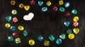 Colorful plastic gems and white paper heart on black fur background Royalty Free Stock Photo