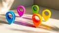 Colorful plastic map markers casting vibrant shadows on a light surface Royalty Free Stock Photo