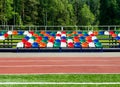 Colorful empty stands in a stadium. Red, blue, green, white, orange plastic seats. Royalty Free Stock Photo