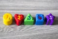 Colorful plastic shapes with numbers on a wooden background