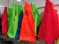 Colorful plastic shopping bags hang on supermarket shelf. Royalty Free Stock Photo