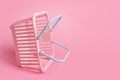 Colorful plastic shopping baskets. Empty pink and blue supermarket basket on pink pastel background. Creative minimalist