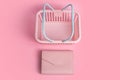 Colorful plastic shopping baskets with leather wallet. Empty pink and blue supermarket basket on pink pastel background