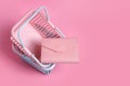 Colorful plastic shopping baskets with leather wallet. Empty pink and blue supermarket baskets on pink pastel background. Creative