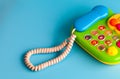 Colorful plastic toy mobile phone on a blue background for children. Royalty Free Stock Photo