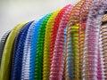 Colorful plastic tubes hanging in a row at a workshop during daylight hours in a bright environment with natural light on Royalty Free Stock Photo