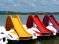 Colorful plastic water slides on small lake with green sater edge and blue sky