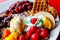 Colorful plate of freshly made waffles with fresh fruits and berries and ice cream Royalty Free Stock Photo