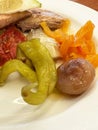 Colorful plate with peppers, pickles, tomatoes, and roasted chicken Royalty Free Stock Photo