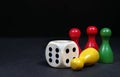 Colorful play figures with dice on black board. copy space Royalty Free Stock Photo
