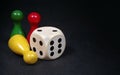 Colorful play figures with dice on black board. copy space Royalty Free Stock Photo