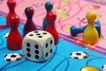 Colorful play figures with dice on black board. copy space Royalty Free Stock Photo