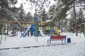 Colorful playground is covered snow at the winter