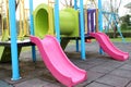 Colorful playground in public park, slide and swing. Royalty Free Stock Photo