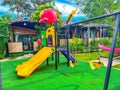 A colorful playground with a slide and swings. children playground and kids place. Royalty Free Stock Photo