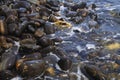 Colorful polished rocks touching wave Royalty Free Stock Photo