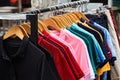 Colorful polo t-shirt for man on wooden hangers in a retail shop