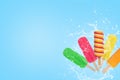 Colorful popsicles ice cream splash on blue background with copy space