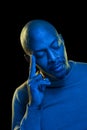 Portrait of a black man with thoughtful expression. Light with blue gel