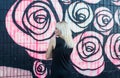 Colorful portrait of pretty young blond woman posing on graffiti wall background in black dress