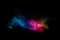 Colorful powder explosion on black background. Abstract pastel color dust particles splash