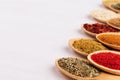 Colorful powder spices on white wooden board with copy space, closeup, texture. Royalty Free Stock Photo