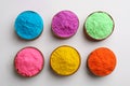 Colorful powders in bowls on light background, flat lay. Holi festival celebration Royalty Free Stock Photo