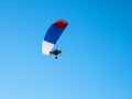Colorful powered paraglider against blue sky. Royalty Free Stock Photo