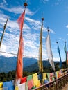 Colorful prayer flags over a clear blue sky near a temple in Bhutan