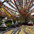 Colorful praying flags in Nepal over white stupas - buddhist religious buildings.