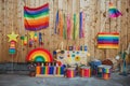 Colorful Pride celebration with wooden floats, rainbow flags, and supportive signs on a wooden background