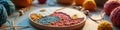 Colorful punch needle embroidery hoop surrounded by yarn balls Royalty Free Stock Photo