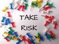 Colorful push pin with the word TAKE RISK