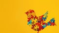 Colorful puzzle pieces arranged in a bird shape on a yellow background. Autistic Pride Day Royalty Free Stock Photo