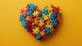 Colorful puzzle pieces forming a heart shape on yellow background. Autistic Pride Day Royalty Free Stock Photo