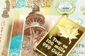 A colorful quarter dinar bill from Kuwait with a gold bar in macro