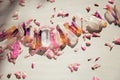 Colorful quartz crystals with pink rose leaves on wooden structure