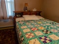 Colorful quilt in drab dark bedroom