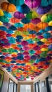 A colorful and quirky image of rainbow umbrellas hanging upside down from the ceiling creating a unique and eye-catching decor