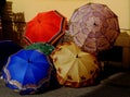 colorful rain umbrellas on display at open market in strong sunlight
