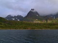 Colorful rainbow above traditional wooden house with red facade on AustvÃÂ¥gÃÂ¸ya island, Lofoten in Norway. Royalty Free Stock Photo