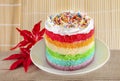 Colorful rainbow cakes on white plate with red maple leaf. Royalty Free Stock Photo