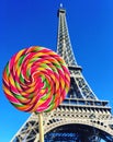 Colorful rainbow lollipop swirl on wooden stick on Eiffel Tower background